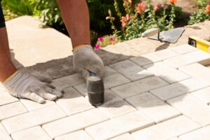 Laying gray concrete paving slabs in house courtyard