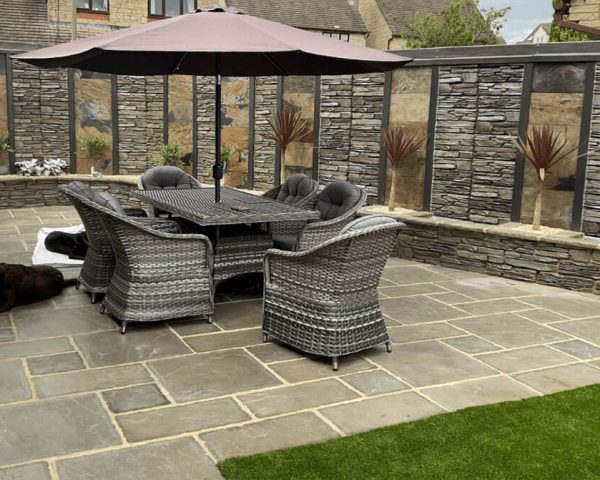 A patio featuring a table surrounded by several chairs, ideal for outdoor dining and relaxation.